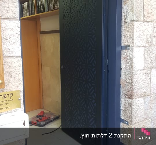 דלת שחורה עם דוגמה גיאומטרית פתוחה למחצה